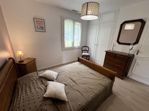 une chambre avec un lit, une commode et un miroir dans l'établissement Résidence 105-st Vivien De Medoc - 105 - Superbe maison avec son grand parc verdoyant MAE-2871, à Saint-Vivien-de-Médoc