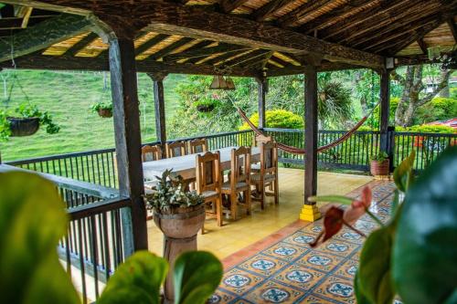 a porch with a hammock and a table and chairs at Finca Panorama Jerico in Jericó