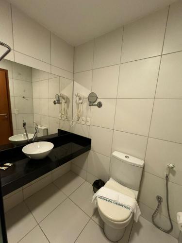 a bathroom with a toilet and a sink at Studio Iloa Vista Piscina 015v in Barra de São Miguel