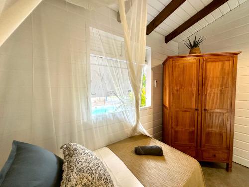 a small bedroom with a bed and a window at Villa Ô Perchée, Vue Mer Panoramique et Piscine Privée in Pointe-Noire