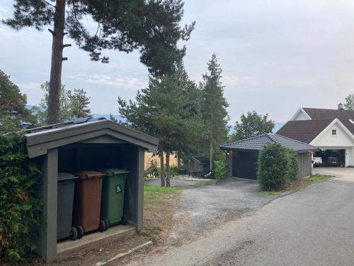 a shed with trash cans in the driveway of a house at Ringåsen in Berg