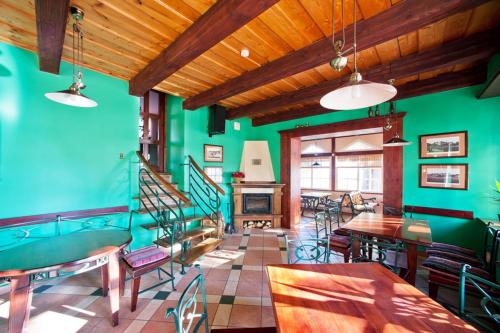 a room with green walls and tables and chairs at Vila Flora in Juodkrantė