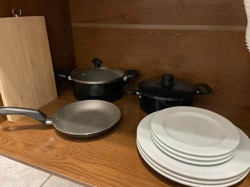 a table with two pots and plates and a strainer at Villa Bilac - Amplos Studios 2km da Vila Germânica in Blumenau