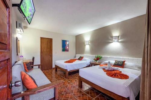 a hotel room with two beds and a couch at Hotel Hacienda Vallarta - Playa Las Glorias in Puerto Vallarta