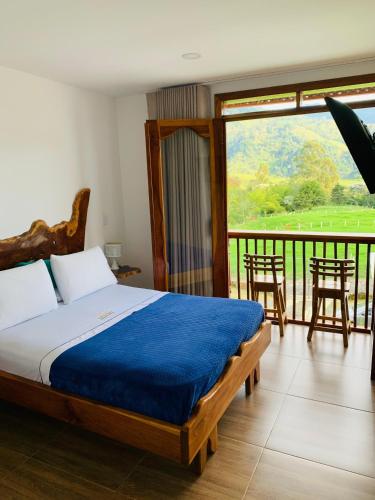 a bedroom with a bed and a balcony with a view at Hospedaje Vista Hermosa Salento in Salento