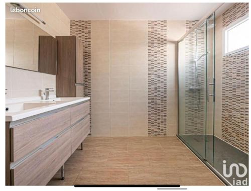 une salle de bain avec un lavabo et une douche en verre dans l'établissement Maison type Villa avec piscine à 400 m du circuit des 24h, au Mans