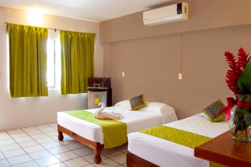 a room with two beds and a swan on a chair at Hotel Hacienda Vallarta - Playa Las Glorias in Puerto Vallarta