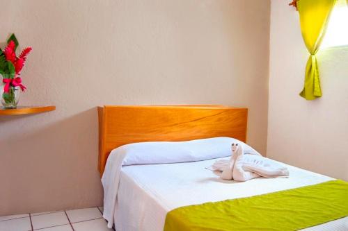 a room with a bed with a stuffed animal on it at Hotel Hacienda Vallarta - Playa Las Glorias in Puerto Vallarta