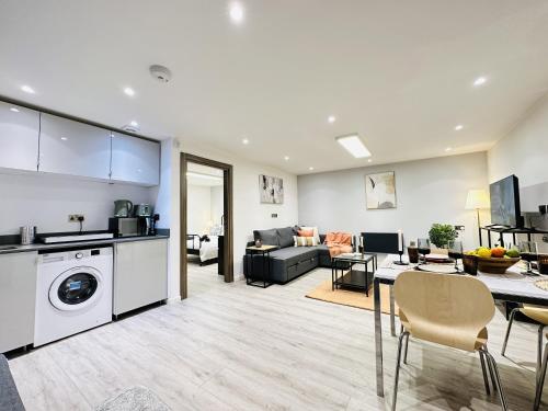 a living room with a kitchen and a living room with a washer at GoldersGreen Apartments by Sleepy in London