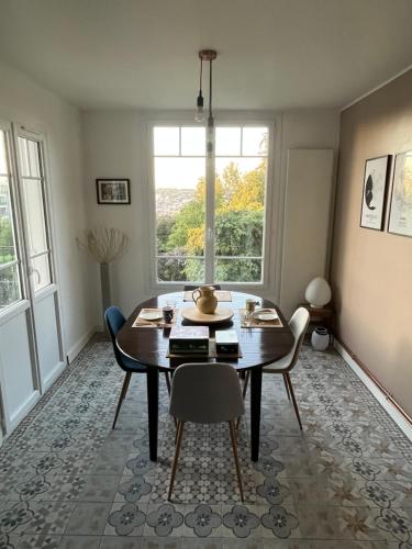 une salle à manger avec une table et des chaises et une fenêtre dans l'établissement Chambre villa du sentier, à Pomponne