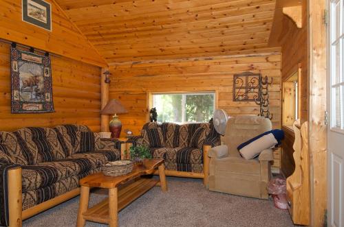 a living room with couches and chairs in a log cabin at Remington Retreat in Island Park
