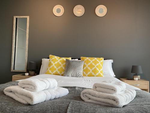 a bedroom with a bed with towels on it at Tailor That Property - Chelsea House in Milton Keynes