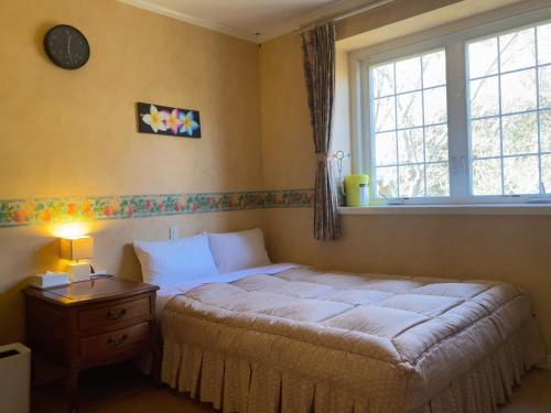 a bedroom with a bed and a window at Miles Town in Ito
