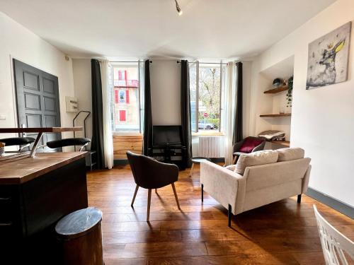 un salon avec un canapé et des chaises dans l'établissement Joli appartement en centre ville, à Bagnères-de-Bigorre