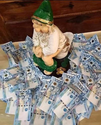 a gnome sitting on top of a pile of money at chrisloner1992 in Paniqui
