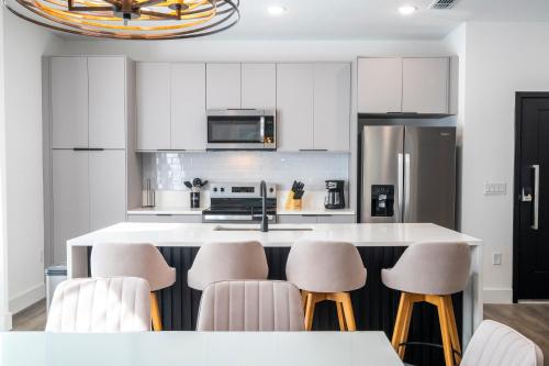 a kitchen with white cabinets and bar stools at Doppio Westside in Orlando
