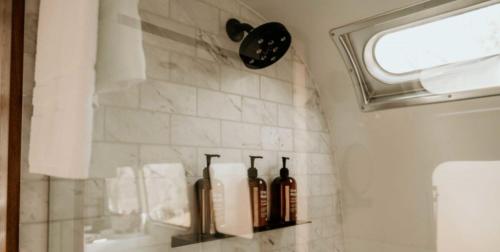 three bottles sitting on a shelf in a bathroom at AutoCamp Sequoia in Three Rivers
