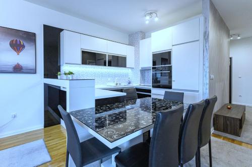 a kitchen with a black and white table and chairs at PLEASURE LUX Bg in Belgrade