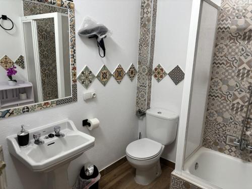 a bathroom with a toilet and a sink and a shower at Alojamientos Capri in Quesada