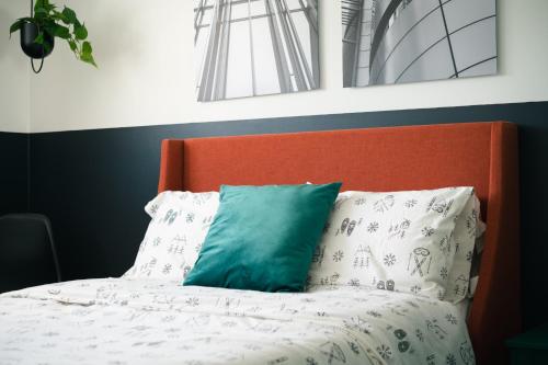 a bed with an orange headboard and a green pillow at La Maison du Sentier - Foyer et Mt Porphyre in Murdochville