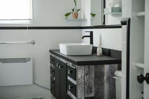 a bathroom with a sink and a toilet and a tub at La Maison du Sentier - Foyer et Mt Porphyre in Murdochville