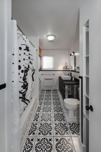 a bathroom with a black and white tile floor at La Maison du Sentier - Foyer et Mt Porphyre in Murdochville