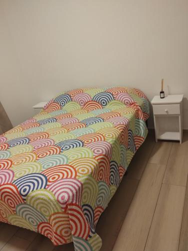 un letto con un piumone colorato in una camera di Depto centrico a La Plata