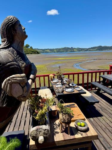 a statue of a woman sitting on a table with plants at Bledford Chiloé in Castro