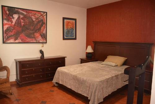 a bedroom with a bed and a painting on the wall at Hotel Casa San Miguel Arcángel in Oaxaca City