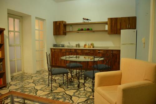 a kitchen with a table and chairs and a refrigerator at Hotel Casa San Miguel Arcángel in Oaxaca City