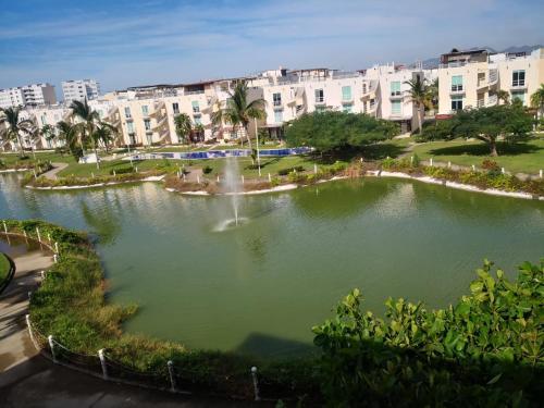 a pond with a fountain in the middle of a city at Marina Independence - Dpto K-01 in Acapulco