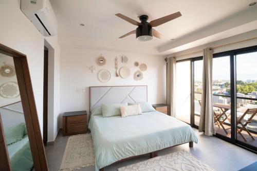 プエルト・バジャルタにあるMountain View Luxury Condo II Céntricoのベッドと天井扇風機のある寝室