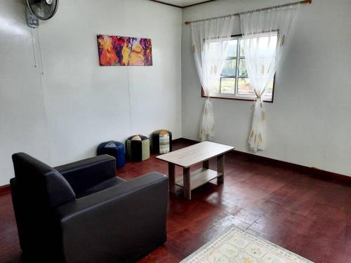a living room with a couch and a table at Eskol Valley Cottage in Ranau