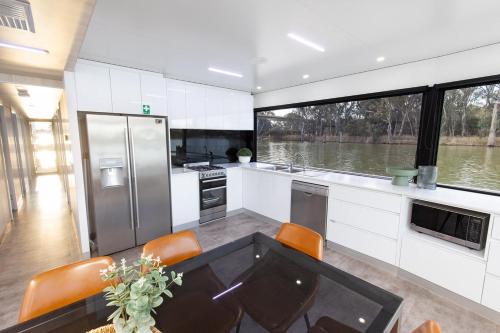 a kitchen with a table and a large window at All Seasons Houseboats in Mildura