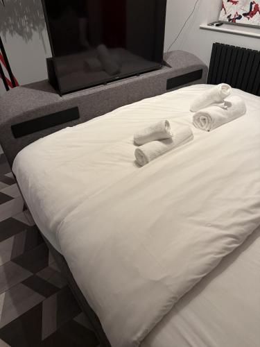 a white bed with towels on top of it at Beautiful 5 Bedroom Home Sleeps 12 people in Manchester in Manchester