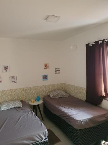 a bedroom with two beds and a small table at Ap Morada Nova in Petrolina