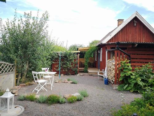 a patio with a table and chairs in front of a building at Niedliches Schwedenhaus in Mönsterås