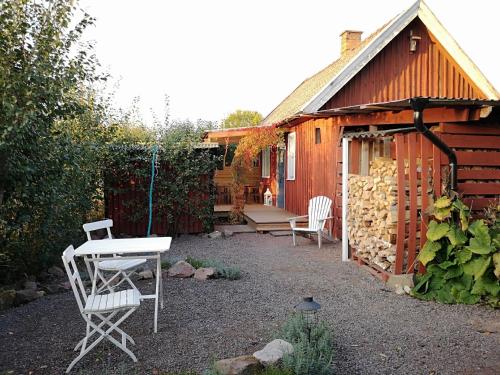 a garden with a table and chairs and a shed at Niedliches Schwedenhaus in Mönsterås