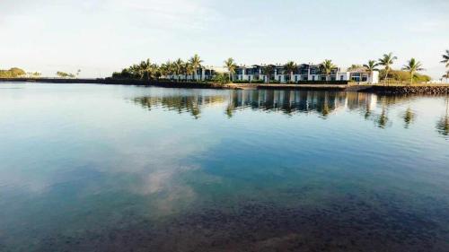 a large body of water with palm trees and houses at Taumeasina Coconut Terrace Villa 1 in Apia