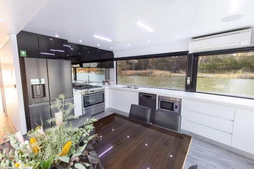 a kitchen with stainless steel appliances and windows at All Seasons Houseboats in Mildura