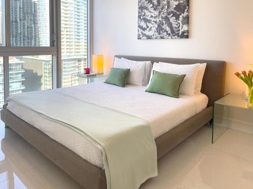 a bedroom with a large bed with two green pillows at Brickell by Miami Vacation Rentals in Miami
