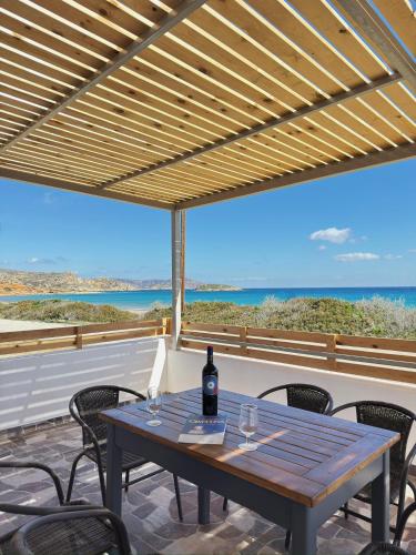 a table with a bottle of wine sitting on a patio at Villa Del Mare in Karpathos Town