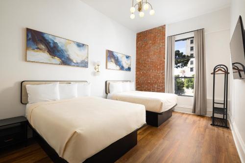 a hotel room with two beds and a window at The Beau Hotel Downtown San Diego Gaslamp Quarter in San Diego