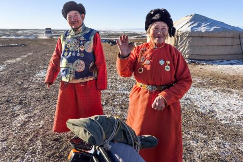 a man and a woman standing next to a motorcycle at Gobi-Girl in Ulaanbaatar