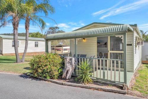 a small house with a porch and palm trees at Ingenia Holidays One Mile Beach in One Mile
