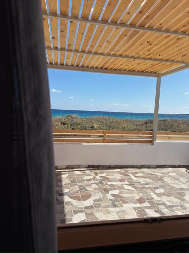 a room with a view of the ocean from a window at Villa Del Mare in Karpathos Town