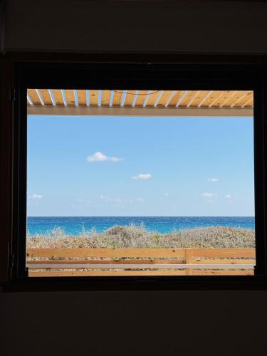a window with a view of the ocean at Villa Del Mare in Karpathos Town