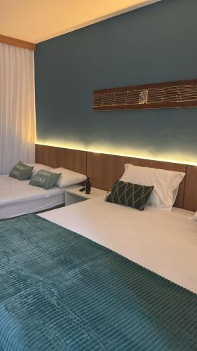 two beds sitting next to each other in a room at Studio Iloa Vista Piscina 004V in Barra de São Miguel