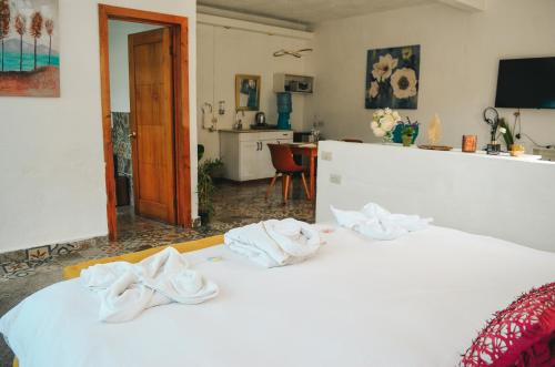 TIBERIAS by luxury Atitlan في سان بيدرو لا لاغونا: غرفة نوم عليها سرير وفوط بيضاء