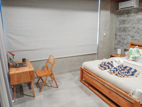 a bedroom with a bed and a desk and a chair at Umah Adenium Ubud 2 in Tegalalang